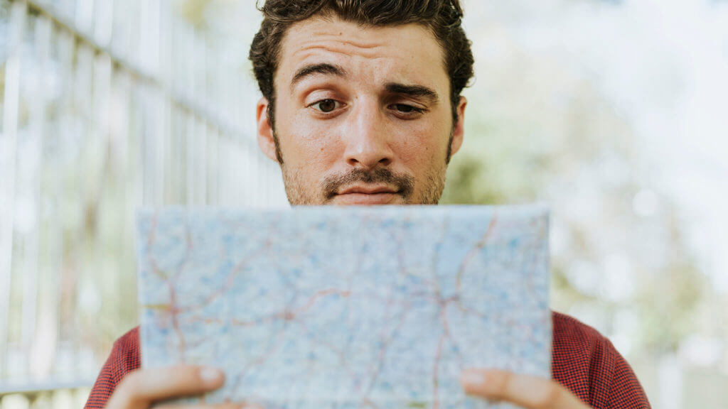 Puzzled man looking at a map